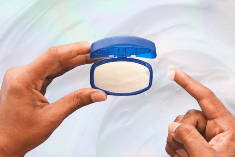 Hands scooping out petroleum jelly from tub