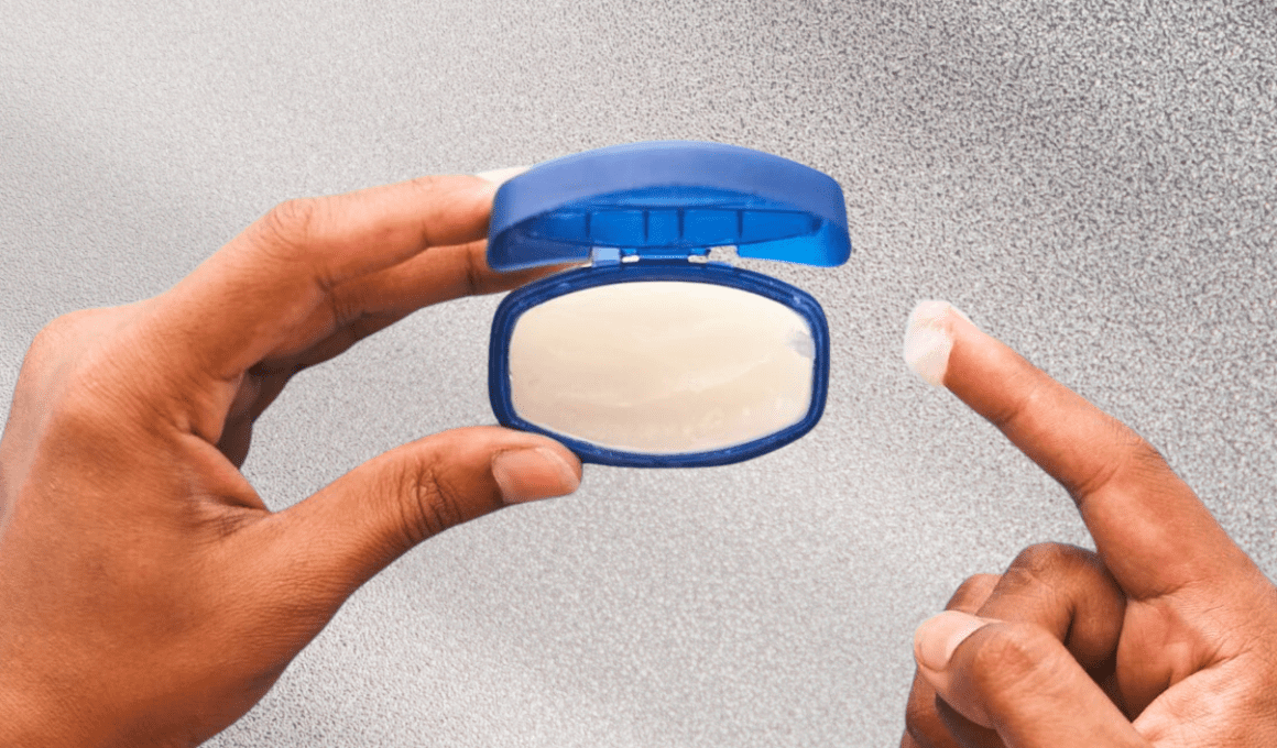 Hands scooping out petroleum jelly from tub