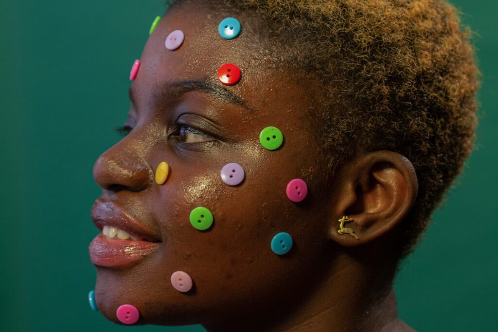 Women with colorful buttons on her face