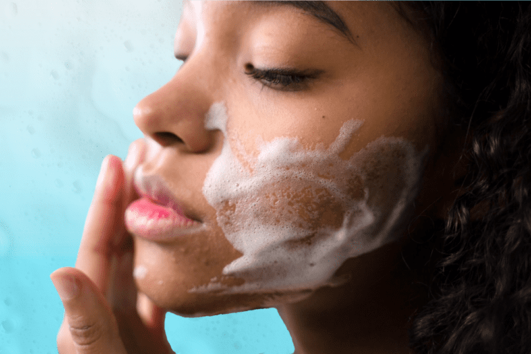 Woman with mild acne washes face with foaming face wash