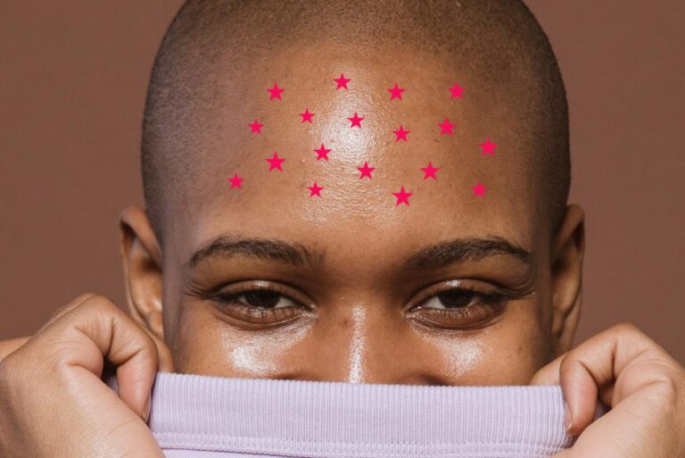 Woman looks at camera with red stars on forehead
