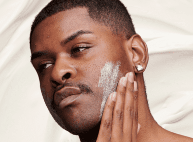 Man with mild acne practices face basting by applying thick white cream to face