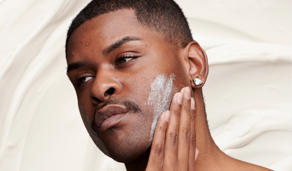 Man with mild acne practices face basting by applying thick white cream to face